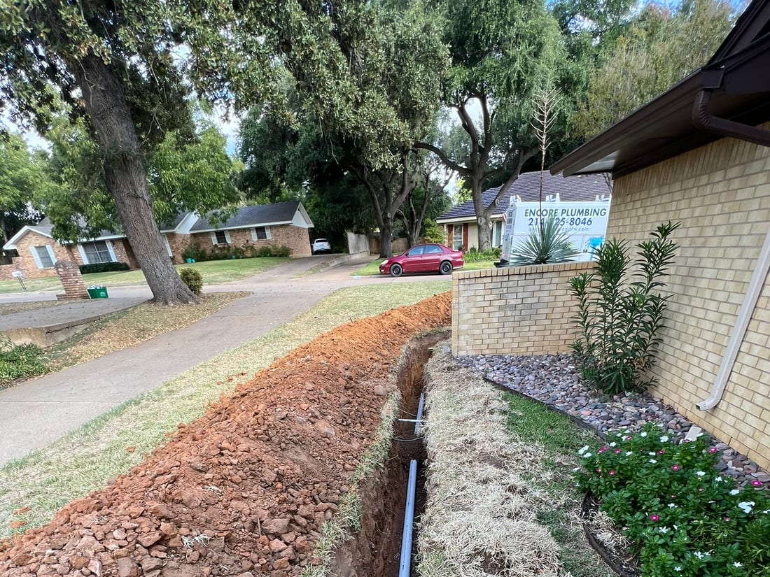 A trenched water line running from the curb to the house by Encore Plumbing, Arlington