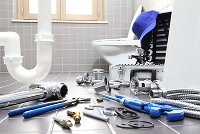 tools used for plumbing installation scattered in a bathroom floor