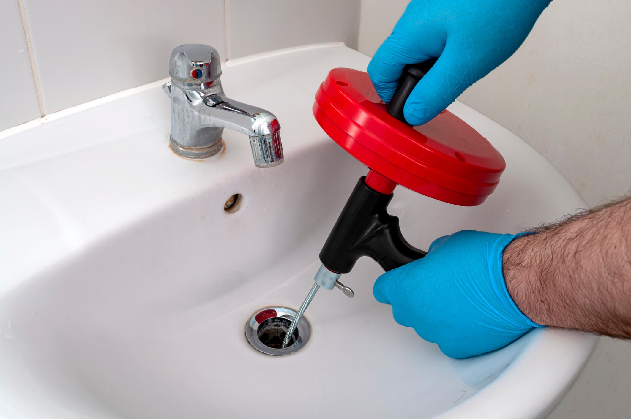 Plumber performing a drain cleaning